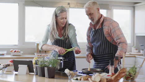 Pareja-Caucásica-De-Mediana-Edad-Preparando-Comida,-Cocinando-Juntos-En-La-Cocina-De-Casa,-Cámara-Lenta