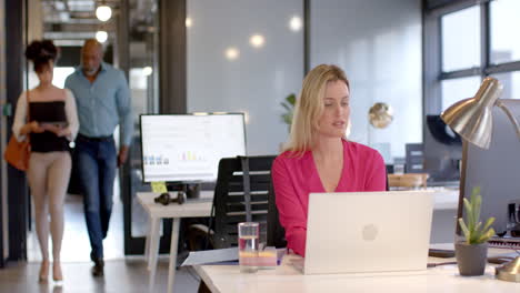 Caucasian-businesswoman-using-laptop-in-office-with-copy-space