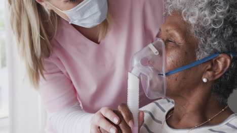 Caucasian-female-nurse-in-face-mask,-senior-african-american-woman-with-oxygen-mask,-slow-motion