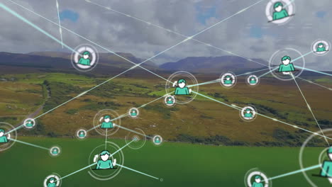 Animación-De-íconos-Conectados-Sobre-Vista-Aérea-De-Tierra-Verde-Contra-Montañas-Y-Cielo-Nublado