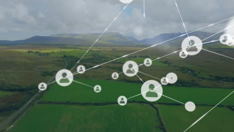 Animation-of-connected-icons-over-aerial-view-of-moving-vehicle-beside-green-land-against-mountains