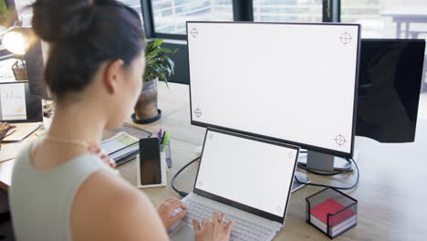 Mujer-De-Negocios-Asiática-Usando-Tableta-Y-Computadora-Con-Pantalla-En-Blanco-En-La-Oficina,-Cámara-Lenta,-Espacio-De-Copia