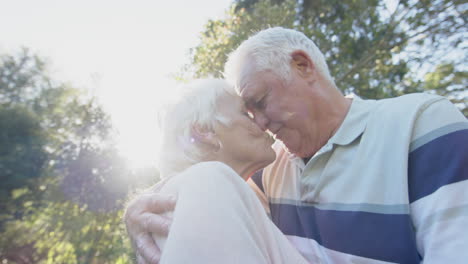 Feliz-Pareja-Caucásica-Mayor-Abrazándose-En-Un-Jardín-Soleado,-Cámara-Lenta