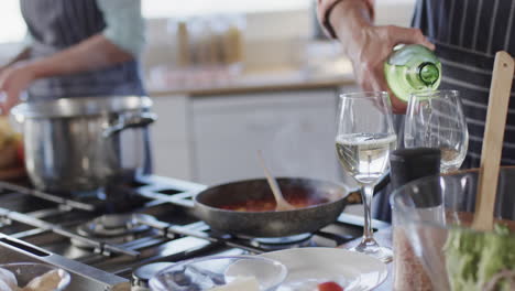 Pareja-Caucásica-Sirviendo-Vino,-Preparando-Comida,-Cocinando-Juntos-En-La-Cocina-De-Casa,-Cámara-Lenta