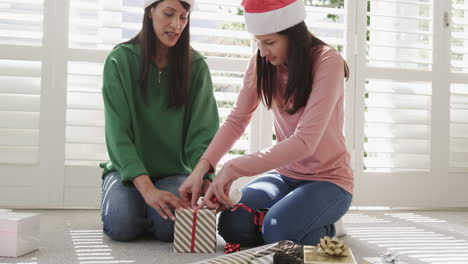 Feliz-Madre-Birracial-E-Hija-Adulta-Envolviendo-Regalos-De-Navidad-En-Casa,-Espacio-Para-Copiar,-Cámara-Lenta