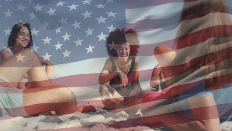 Animation-of-national-flag-of-america-waving-over-diverse-friends-sitting-and-enjoying-at-beach