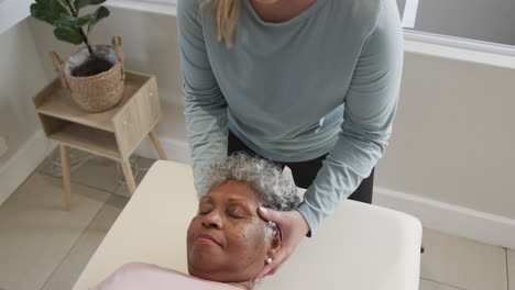 Fisioterapeuta-Femenina-Caucásica-Masajeando-Cabeza-De-Mujer-Mayor,-Espacio-De-Copia,-Cámara-Lenta