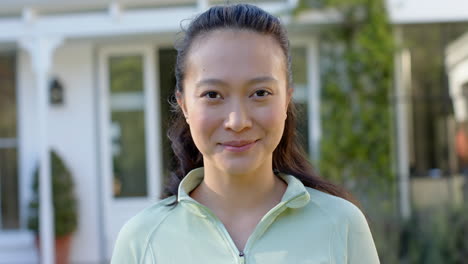 Portrait-of-happy-biracial-woman-smiling-in-garden,-slow-motion