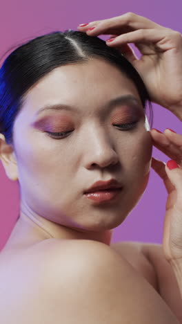 Vertikales-Video-Einer-Asiatischen-Frau-Mit-Schwarzem-Haar-Und-Make-up,-Die-Das-Haar-Berührt,-Kopierraum,-Zeitlupe