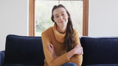 Happy-caucasian-woman-sitting-on-sofa-and-having-video-call-in-sunny-living-room,copy-space