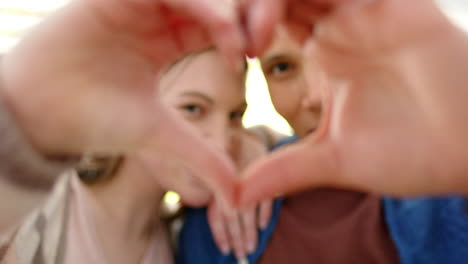 Retrato-De-Una-Feliz-Pareja-Diversa-Haciendo-Forma-De-Corazón-Con-Las-Manos-En-Un-Jardín-Soleado,-En-Cámara-Lenta