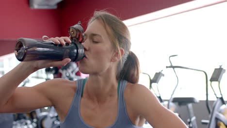 Una-Joven-Caucásica-En-Forma-Se-Hidrata-Durante-Un-Entrenamiento-En-El-Gimnasio.