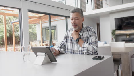 Senior-biracial-man-with-medication-having-video-call-with-doctor-on-tablet,-slow-motion