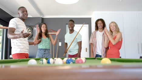 Diverse-group-of-friends-enjoy-a-game-of-pool-at-home