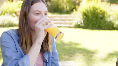 Happy-diverse-couple-having-picnic-in-sunny-garden,-in-slow-motion