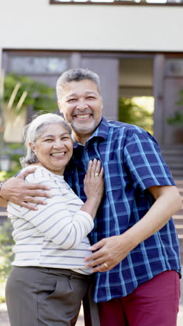 Happy-biracial-senior-couple-embracing-in-sunny-garden