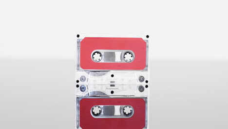 Video-of-retro-cassette-tape-with-red-label-and-reflection-with-copy-space-on-white-background