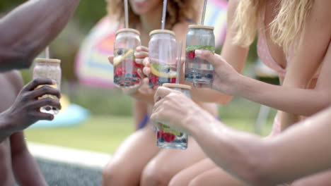 Diverse-friends-toast-with-fruit-infused-water-outdoors