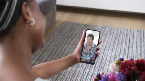 Mujer-Afroamericana-Sosteniendo-Un-Teléfono-Inteligente-Con-Un-Hombre-Birracial-En-La-Pantalla