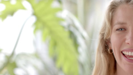 Half-portrait-of-happy-caucasian-woman-with-blonde-hair-smiling-at-home,-copy-space,-slow-motion