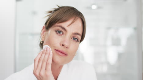 Caucasian-woman-with-brown-hair-is-cleansing-her-face-with-a-cotton-pad