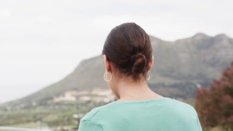 Portrait-of-happy-biracial-woman-standing-on-balcony-at-home,-slow-motion