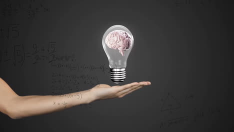 Animation-of-light-bulb-with-brain-over-woman's-hand-and-mathematical-data-processing