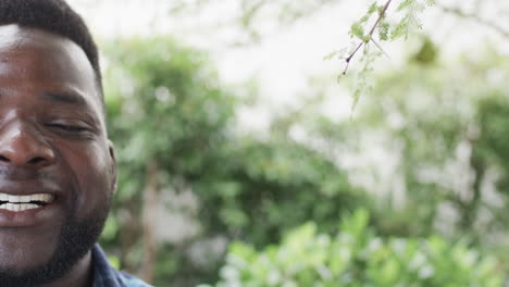 African-American-man-smiles-outdoors,-with-copy-space