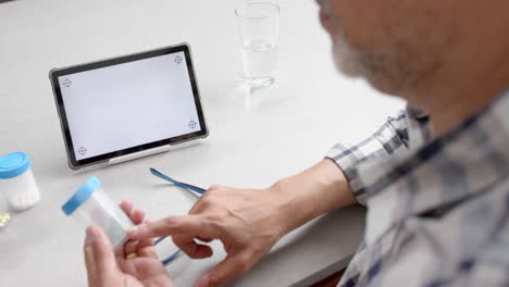 Senior-biracial-man-having-medical-video-call-on-tablet,-copy-space-screen,-slow-motion