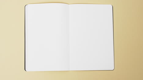 Video-of-book-with-white-blank-pages-and-copy-space-on-yellow-background