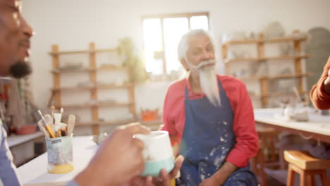 Happy-diverse-group-of-potters-having-break-and-discussing-in-pottery-studio