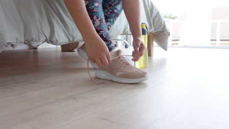 Unterer-Teil-Einer-übergroßen,-Gemischtrassigen-Frau,-Die-Vor-Dem-Training-Sportschuhe-Bindet,-Platz-Zum-Kopieren,-Zeitlupe