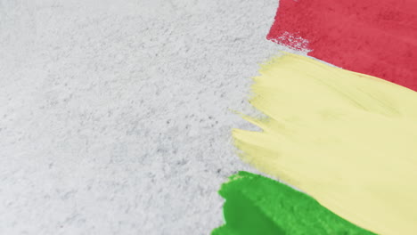 Video-of-red,-yellow-and-green-paint-smudges-with-copy-space-on-grey-background