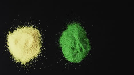 Video-of-red,-yellow-and-green-powders-with-copy-space-on-black-background