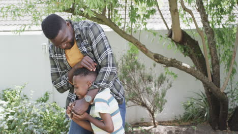 African-American-father-teaches-son-outdoors,-with-copy-space