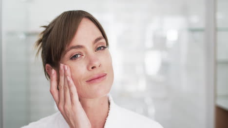 Middle-aged-Caucasian-woman-examines-her-skin-in-a-bright-bathroom