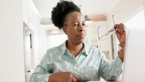 Happy-african-american-senior-woman-with-glasses-smiling-in-sunny-room-at-home,-slow-motion