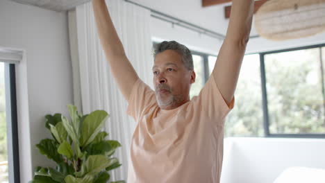 Hombre-Birracial-Mayor-Practicando-Yoga-En-Casa