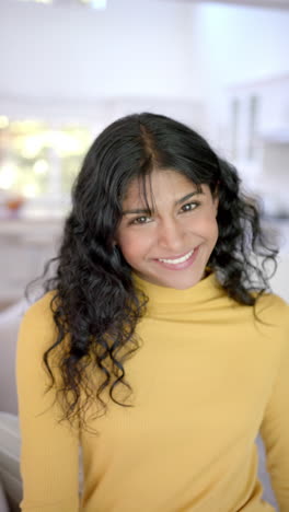 Vertical-video-of-portrait-of-biracial-female-teenager-with-long-hair-at-home,-slow-motion