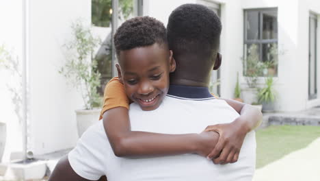 African-American-father-and-son-share-a-warm-hug-outdoors