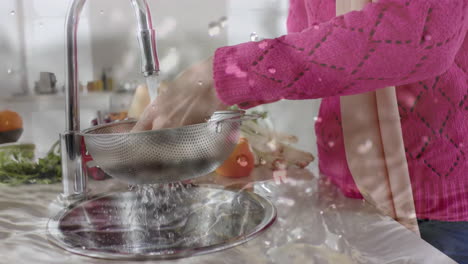 Mujer-Birracial-Lavando-Verduras-En-La-Cocina,-Cocinando-Sobre-Gotas-De-Agua.