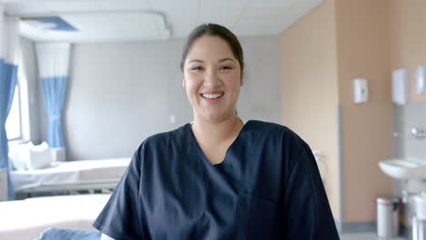 Portrait-of-happy-caucasian-female-doctor-smiling-in-hospital-ward,-copy-space,-slow-motion