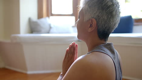 Mujer-Birracial-Senior-Enfocada-Con-Palitos-De-Incienso-Meditando-En-Una-Estera-De-Yoga-En-Casa