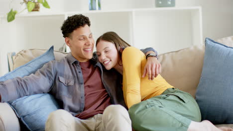 Retrato-De-Una-Feliz-Pareja-Diversa-Sentada-En-Un-Sofá-Abrazándose-En-Casa,-En-Cámara-Lenta