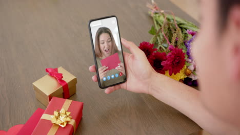 Caucasian-woman-holding-holding-smartphone-with-caucasian-woman-with-envelope-on-screen