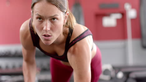 Colocar-A-Una-Joven-Caucásica-Levantando-Pesas-En-El-Gimnasio,-Con-Espacio-Para-Copiar.