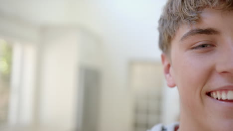 Portrait-of-happy-caucasian-male-teenager-at-home,-copy-space,-slow-motion