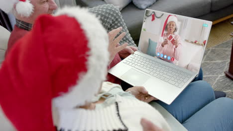 Feliz-Pareja-De-Ancianos-Diversos-Y-Amiga-Teniendo-Videollamada-Navideña-Con-Computadora-Portátil,-Cámara-Lenta