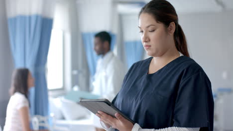 Portrait-of-caucasian-female-doctor-using-tablet-and-smiling-in-ward,-copy-space,-slow-motion