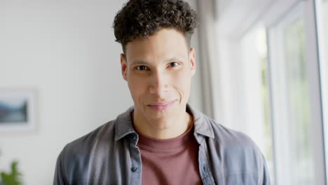 Portrait-of-happy-biracial-man-smiling-at-home,-in-slow-motion